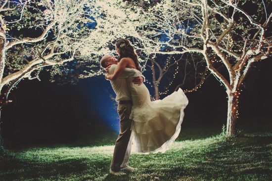 Happy couple embraces under twinkling fairy lights