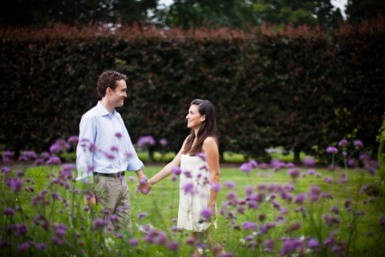 Couple holds hands in a field of purple flowers