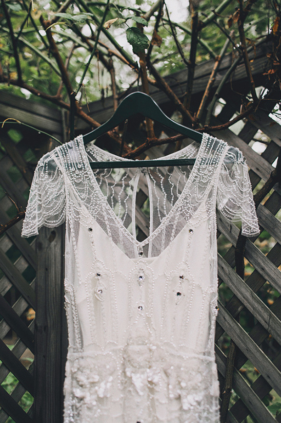 Lace wedding dress hanging on a rustic wooden fence