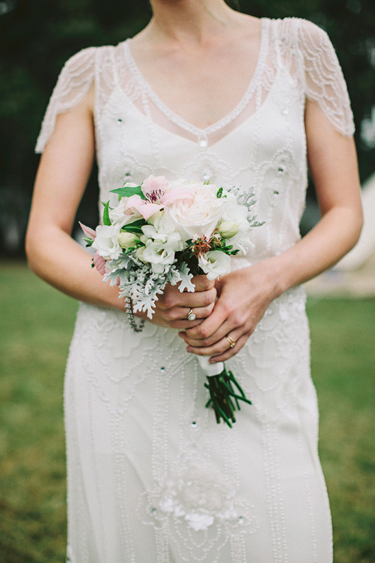 Bride in vintage dress holding her wedding bouquet
