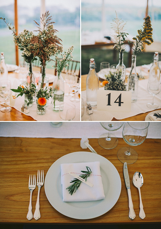 Rustic wedding table setting with wildflowers in bottles
