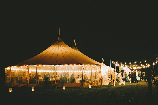 Romantic outdoor wedding reception under a lit tent