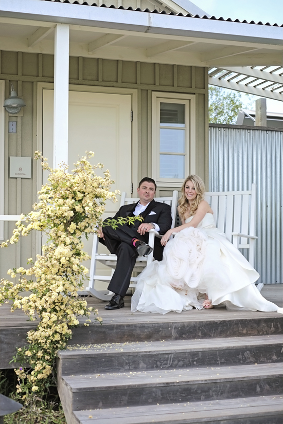 Couple in wedding attire on porch