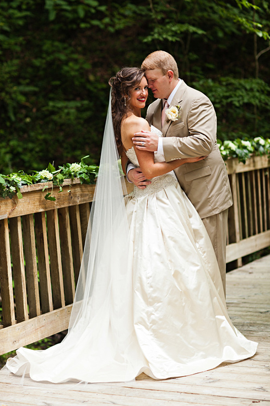 Happy bride and groom on a wooden bridge