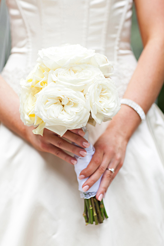 Bride holding elegant white rose wedding bouquet