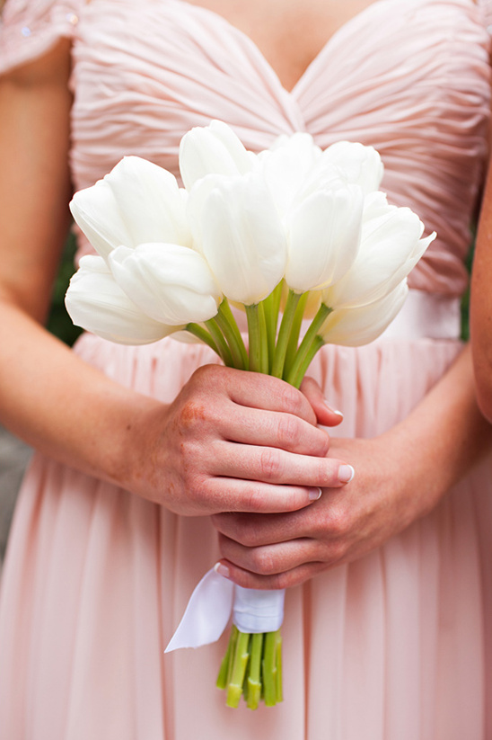 Bridesmaid holding a bouquet of white tulips