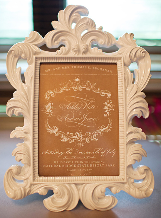 Elegant white frame displays wedding invitation for Ashley & Andrew