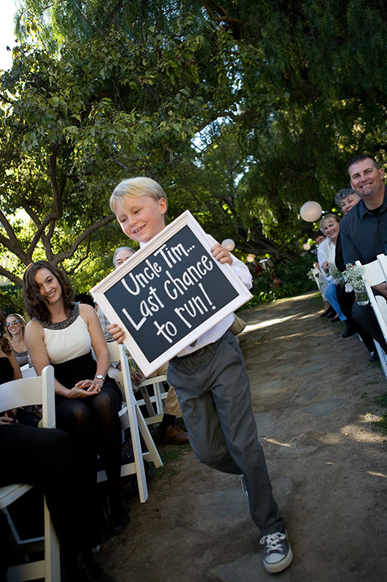 Young boy holding sign Last chance to run at wedding