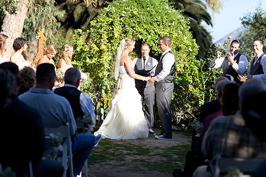 Outdoor wedding ceremony with bride and groom holding hands