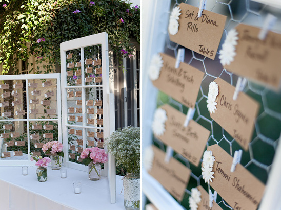 Wedding seating chart displayed on windows with floral accents