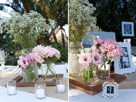 Wedding table decor with pink flowers and candles in jars