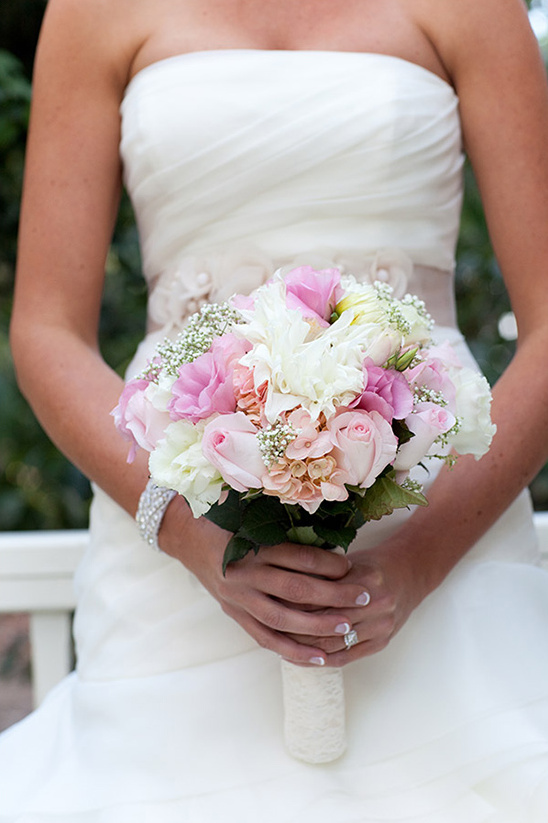 Bride holding a bouquet of pink and white flowers on her wedding day