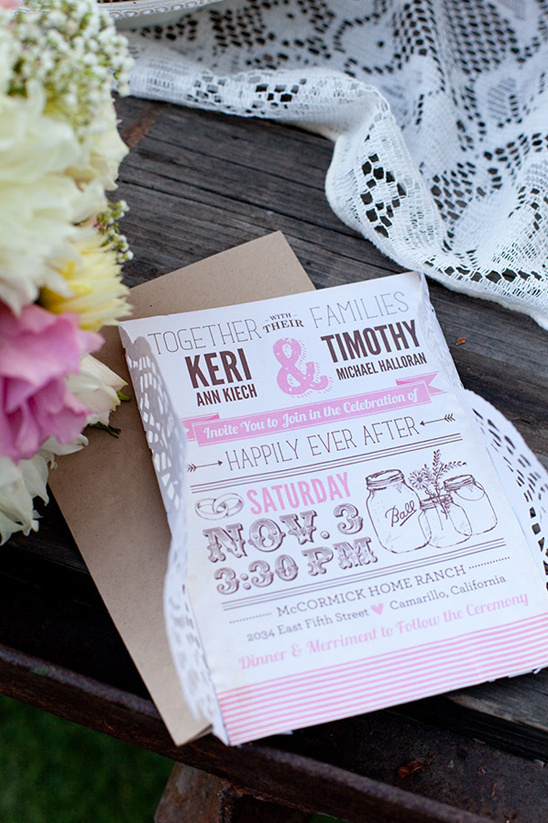 Wedding invitation with floral decorations on wooden surface