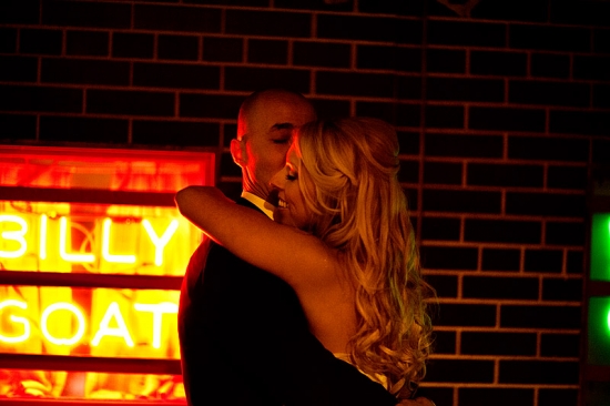 Couple embracing near Billy Goat neon sign