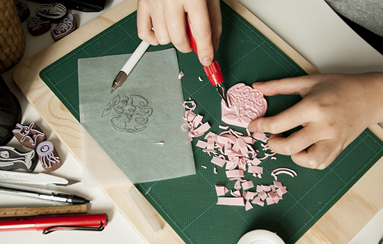 Hand carving a rubber stamp with a craft knife tool