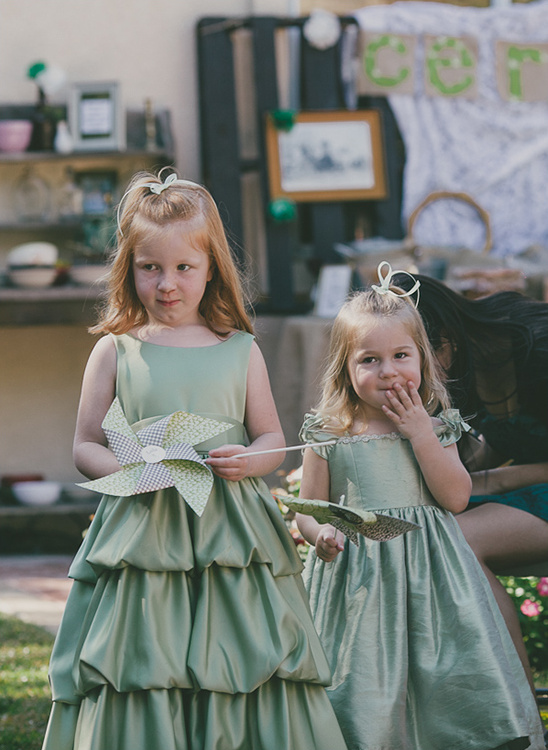 Two girls in green dresses holding pinwheels