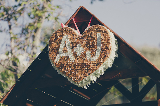 Heart shaped piñata with initials AJ at a wedding