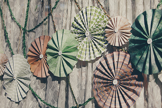 Colorful paper fans used as decorations on a lace background