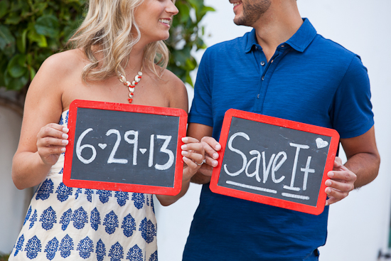 Couple holding chalkboards announcing their wedding date in 2013