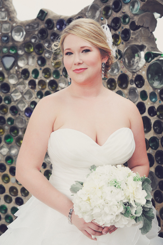 Blonde bride in strapless dress holding white bouquet