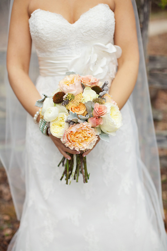 Bride holding bouquet of peach and white roses