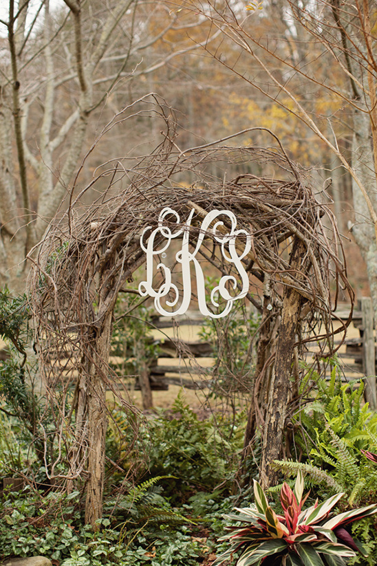 Rustic wedding arch with monogram LKS in natural setting