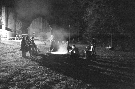 Nighttime campfire gathering by barn