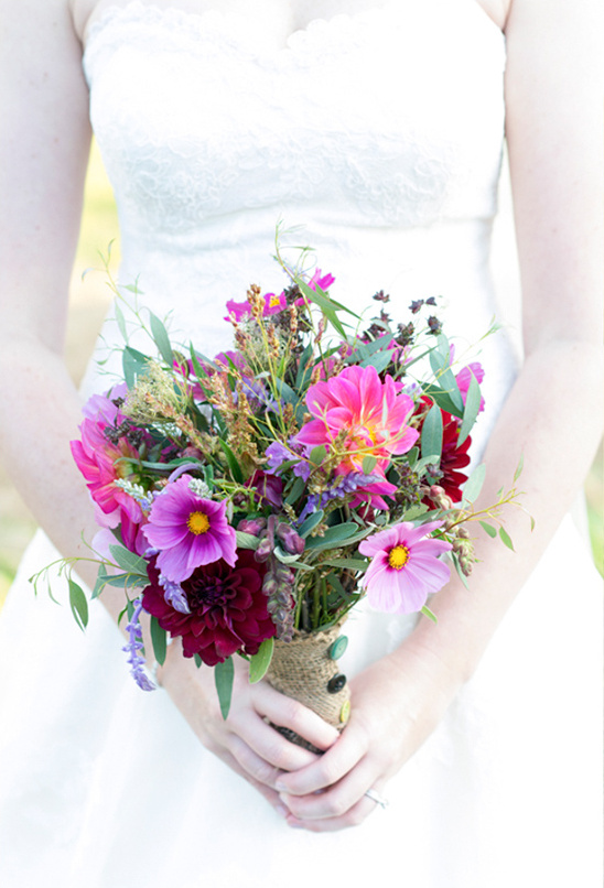 Bride holding vibrant pink and purple wedding bouquet