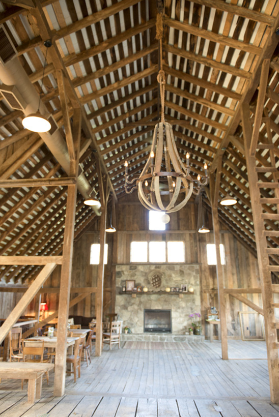 Rustic barn interior with chandelier and fireplace