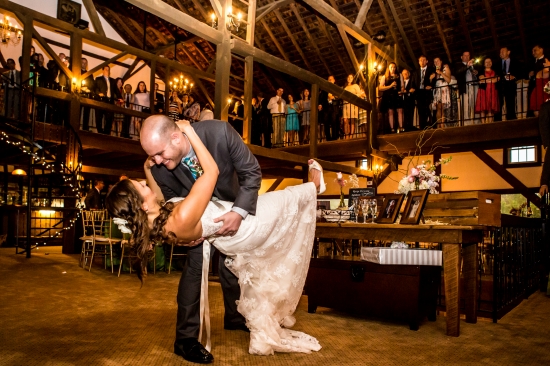 Wedding first dance: groom dips bride in a beautiful barn