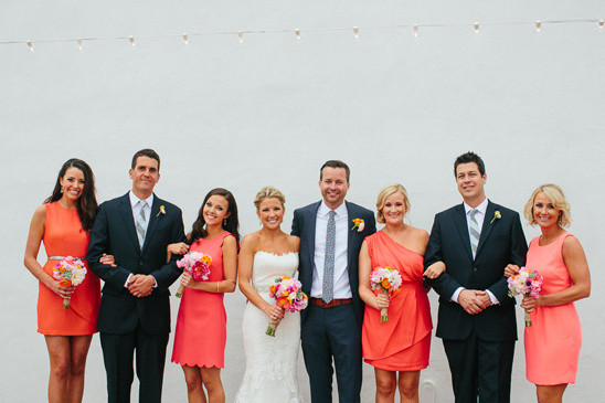 Wedding party poses bridesmaids in coral dresses