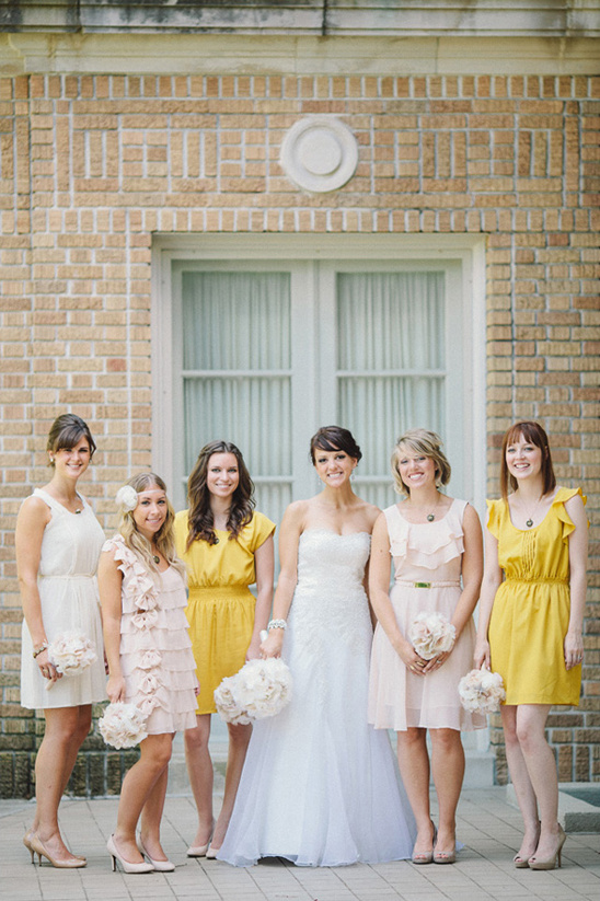 Bridesmaids in yellow and blush dresses with bride