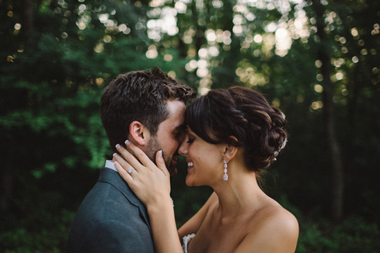 Romantic wedding couple embracing in woods