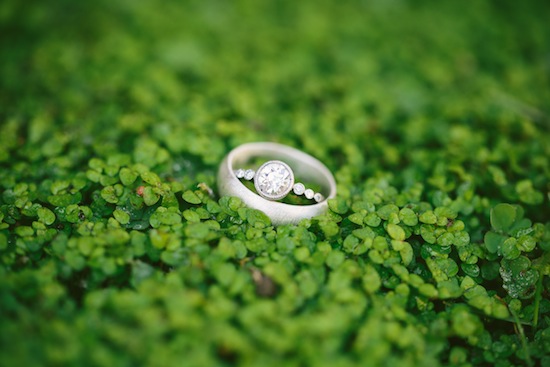 Wedding rings resting on a bed of lush green clover