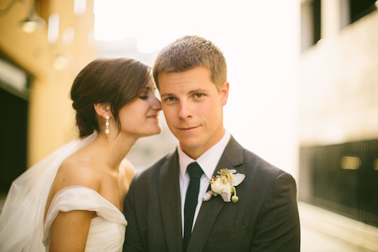 Bride whispering to groom during outdoor wedding