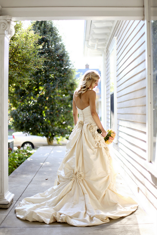 Bride in gown with floral details on porch