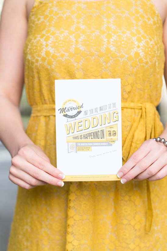 Woman holds yellow wedding invitation card closeup