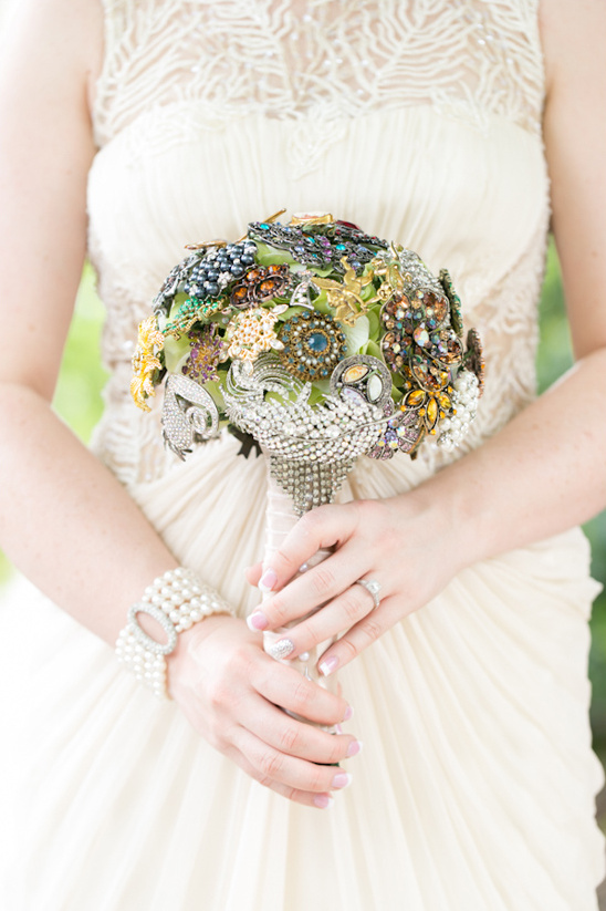 Bride holding vintage brooch bouquet