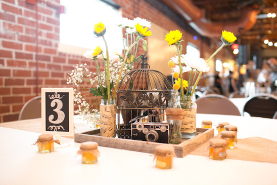 Rustic wedding table centerpiece: flowers, birdcage, camera, table number 3