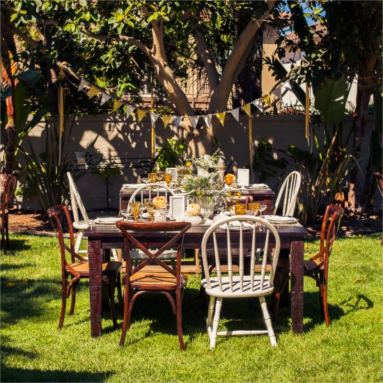Outdoor garden party table setting with rustic chairs