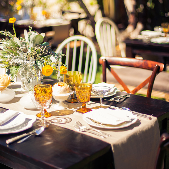 Rustic outdoor wedding table setting with yellow flowers