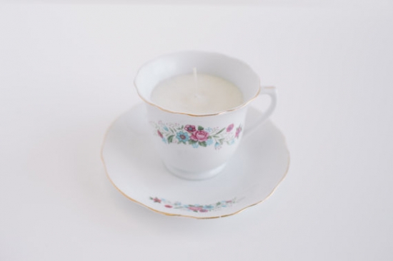 Teacup candle, floral pattern teacup and saucer on a white background