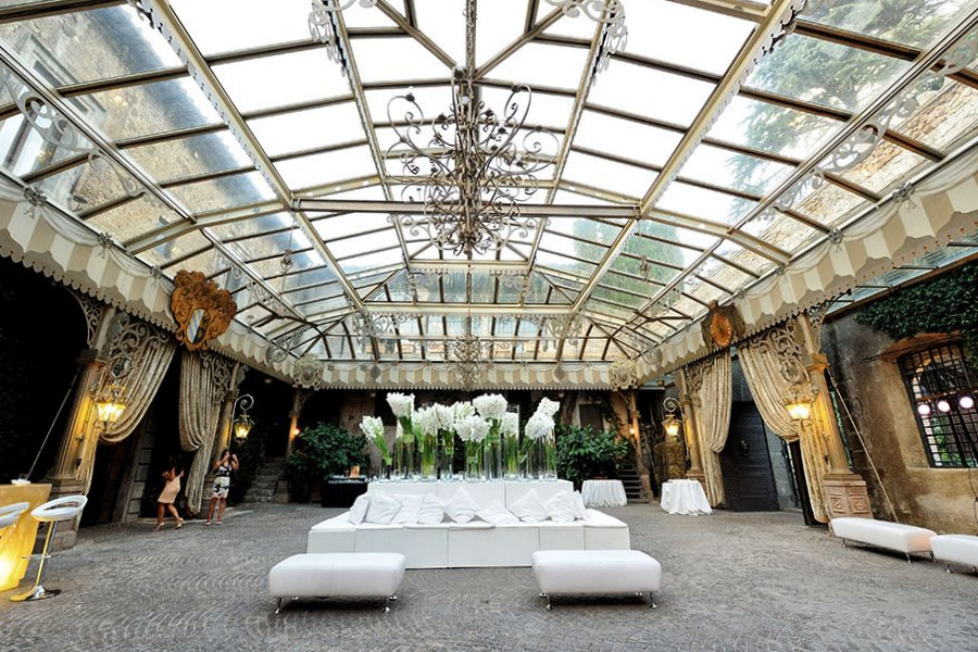 Elegant glass-roofed venue with beautiful floral arrangement and chandeliers