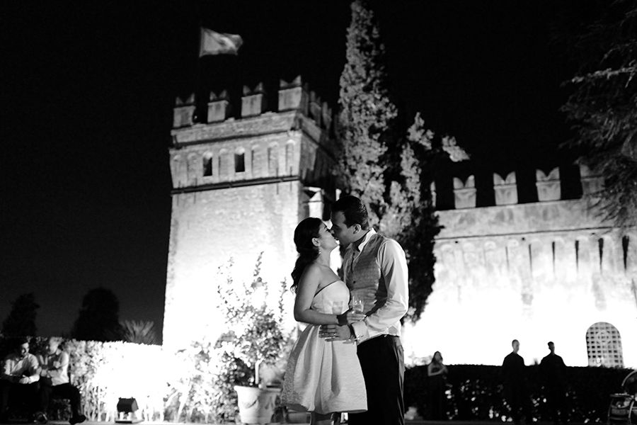 Newlyweds share a kiss under the castle's night sky