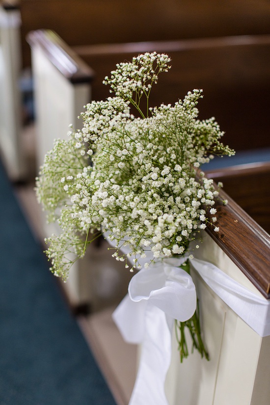 Wedding flowers tied to pews