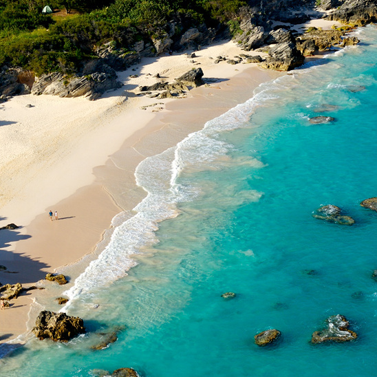 Aerial view of a stunning turquoise beach and rocky coast