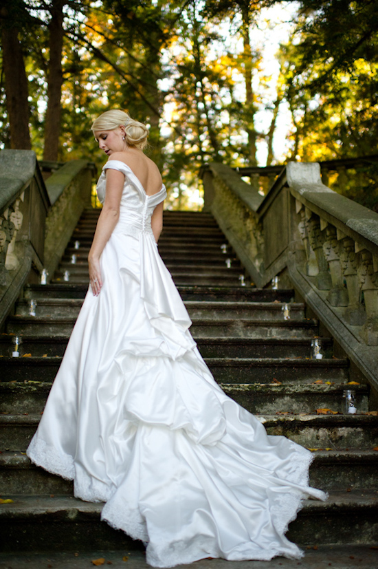 Bride in elegant satin wedding gown on stairs