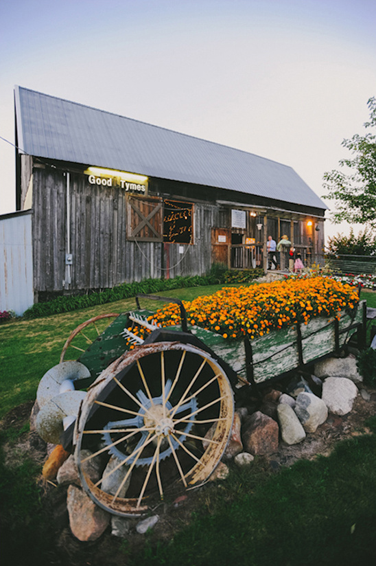 Old barn with Good Tymes sign and flower cart in front