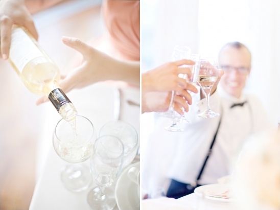 Pouring white wine into glasses with a toasting gesture in the background