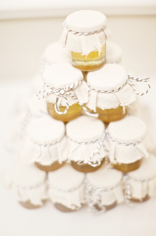 Small jars of honey with fabric tops, stacked like a pyramid